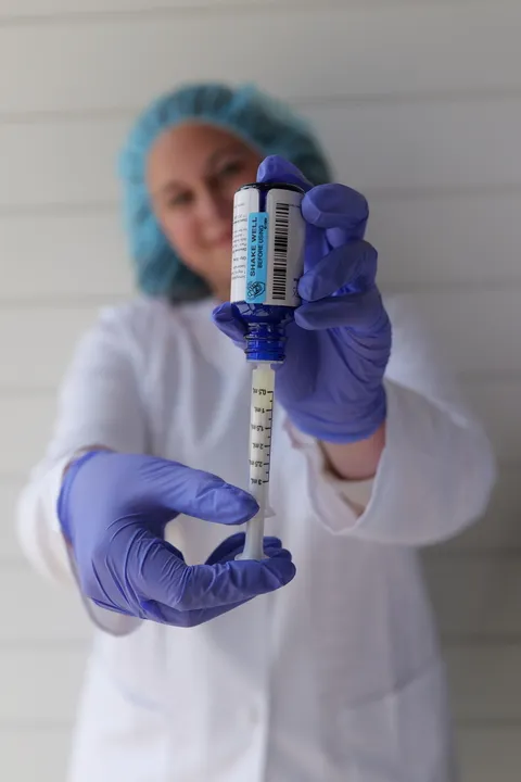 A woman takes her oral medication from a dropper.